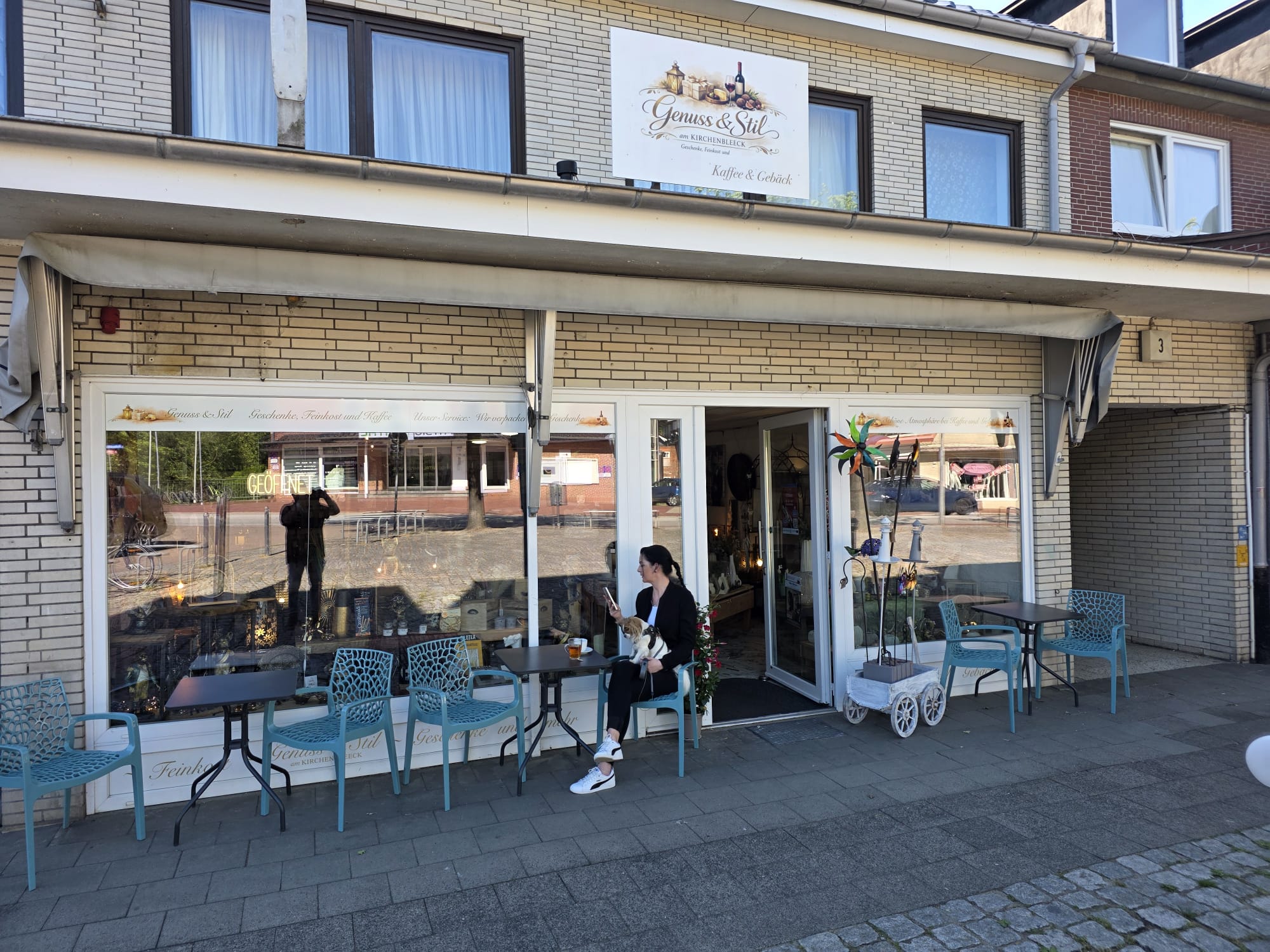 Terrasse vor Genuss & Stil mit Tischen und Stühlen in der Abendsonne